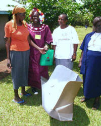 Elizabeth Oranga (center) earns income by demonstrating and selling solar cookers in her community